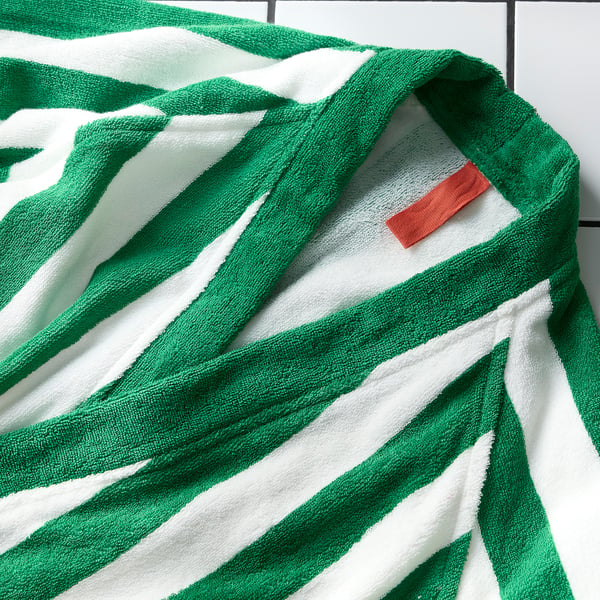 Green and white striped bath towel with a red tag, folded neatly, showcasing soft, plush texture.