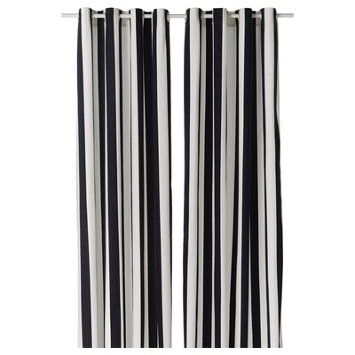 Two tall black and white striped curtains hang side by side. Made of 100% recycled cotton, they feature horizontal stripes and metallic eyelets.