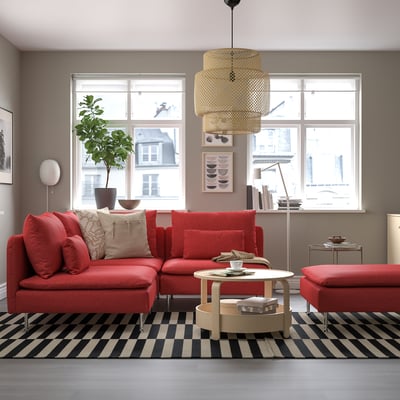 Modern room with red SÖDERHAMN sectional, large windows, black/white chequered rug, wooden coffee table. Cosy, vibrant design.