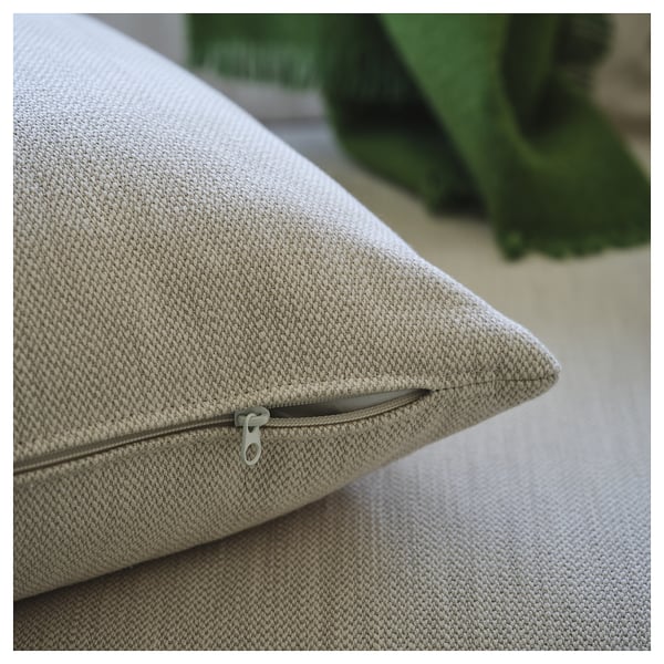 Close-up of beige cushions zip on modern sofa, emphasising comfort and removable cover.