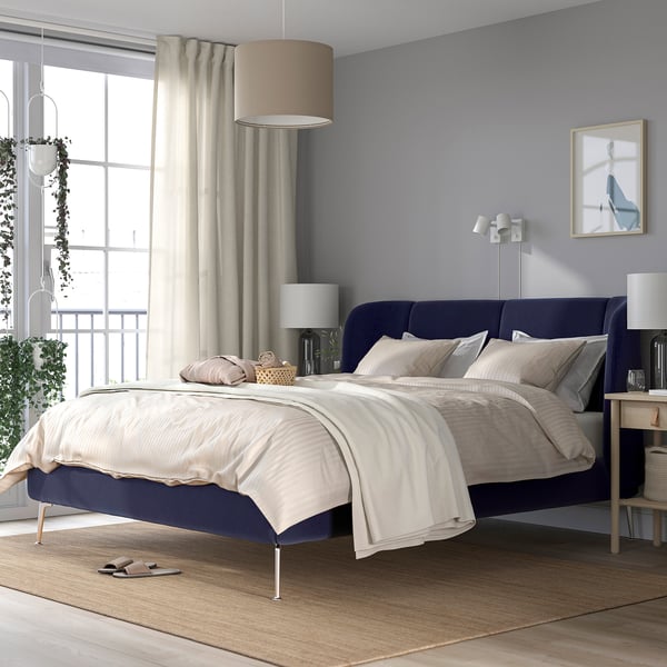 Cosy bedroom with TUFJORD bed, soft headboard, grey walls, white lamps, window with curtains, plant.