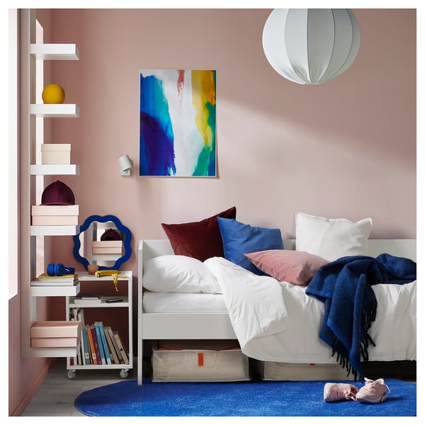 Modern teen bedroom with white VIHALS bed, blue accents, colourful art, and shelves.