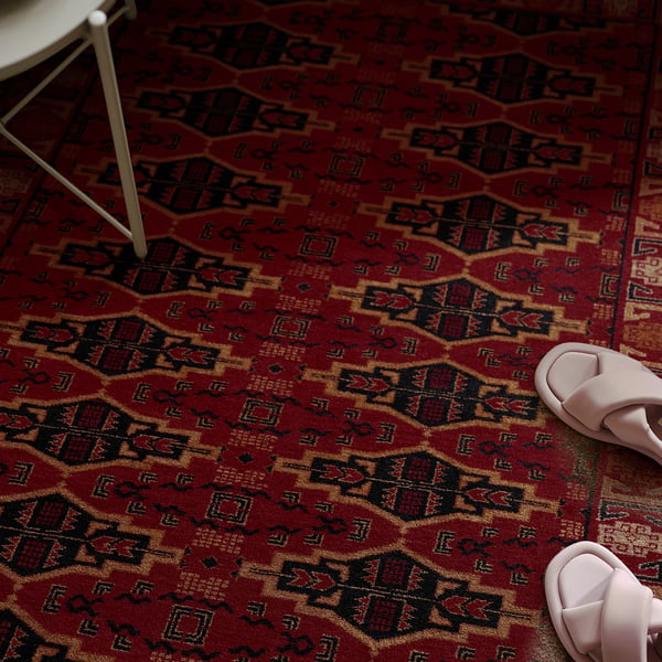 A colourful geometric rug with a pair of pink slippers, showcasing its warmth and comfort, ideal for various floors.