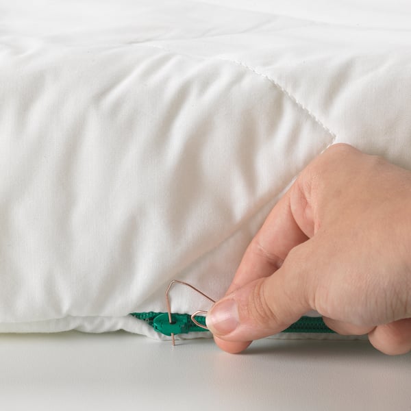 A hand opens a child-safe zip on a 3-part, reversible mattress designed for growth and comfort.