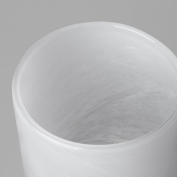 Cylindrical glass vase with smooth, glossy finish. Intricate, swirling pattern inside, reflecting quality craftsmanship.