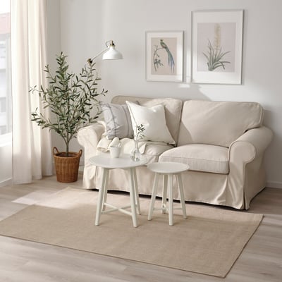 Cosy living room with beige VODSKOV jute rug under sofa, adding warmth.