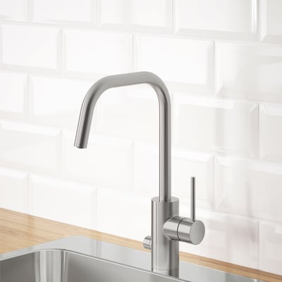 En modern köksblandare i rostfritt stål med en hög bågpip, designad för vatten- och energieffektivitet.