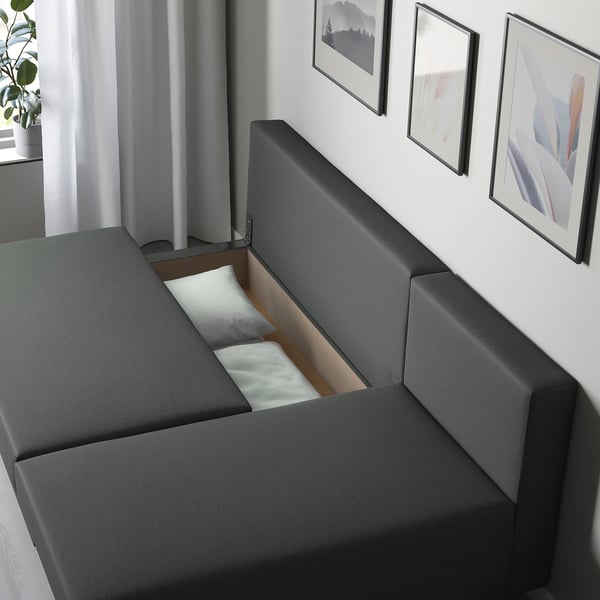 Modern soffa med utfällbar säng, grått tyg, förvaringsutrymme, konvertibel sittplats.