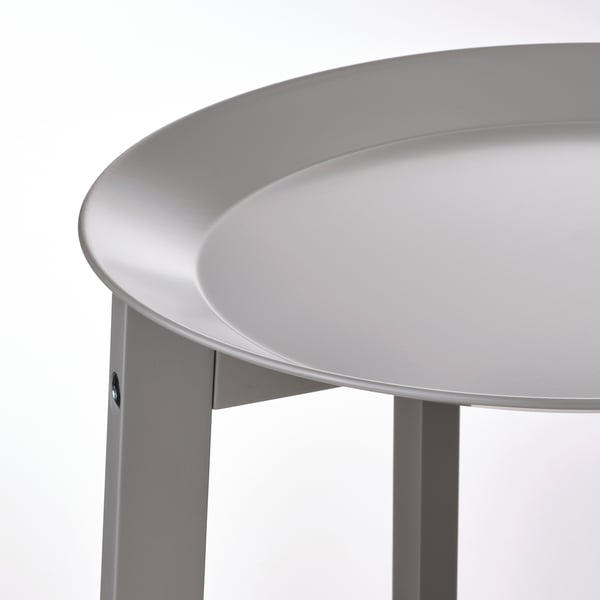 Modernt, runt växtställ med en elegant, vit, rund bricka. Solida träben stöder brickan säkert.