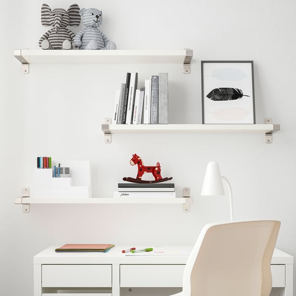 Modernt studieområde för vita barn. Hyllan BERGSHULT rymmer böcker, leksaker och inredning. Skrivbord med stol, lampa och färgglada tillbehör.
