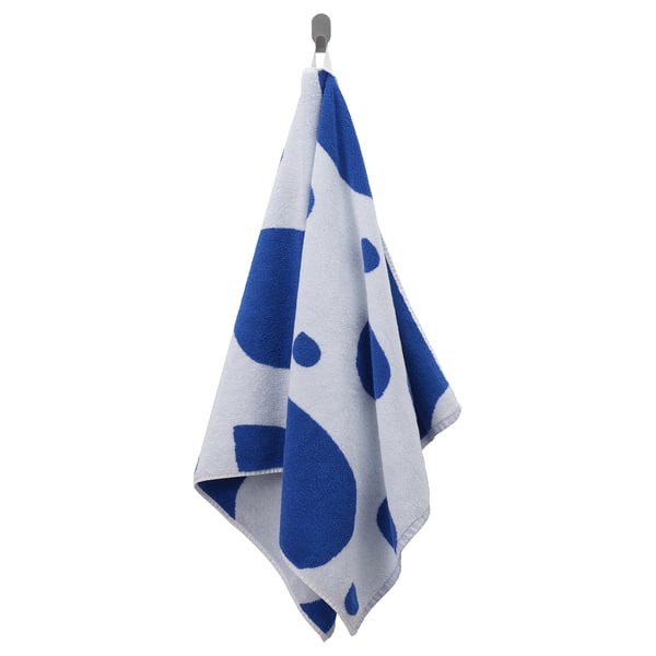 Blå/vit handduk med droppmönster hänger på kroken.