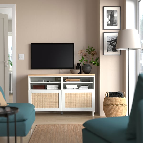 Vit BESTÅ tv-bänk med plattskärm, blågröna stolar, foton, lampa, korg.
