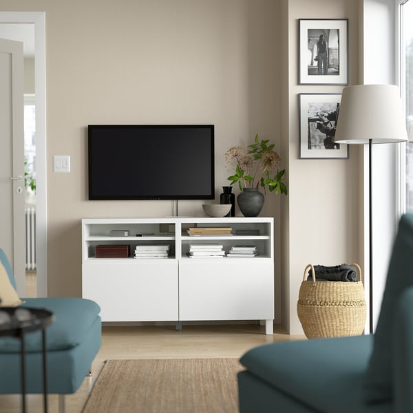 Modernt vardagsrum med BESTÅ-tv-bänk, platt-tv, turkos soffa, lampa och inramade bilder.