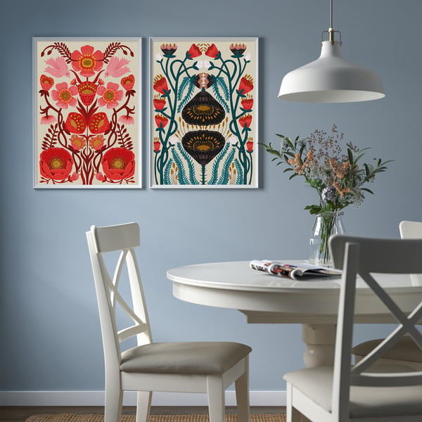 Blommiga affischer ovanför matbord med stolar, lampa.