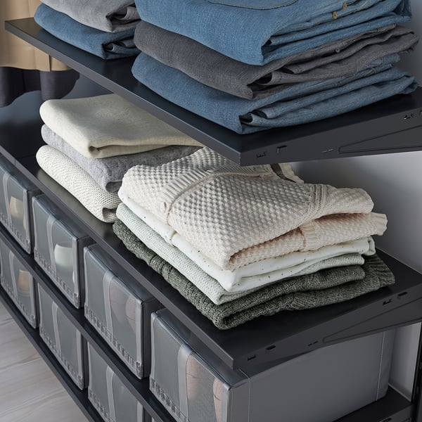 Snyggt organiserad garderob med BOAXEL-hyllor. Jeans, tröjor och lådor.