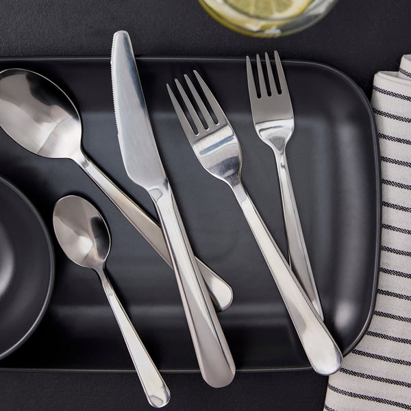 Silverbestick i rostfritt stål på en svart bricka. Eleganta bordsdukningar.