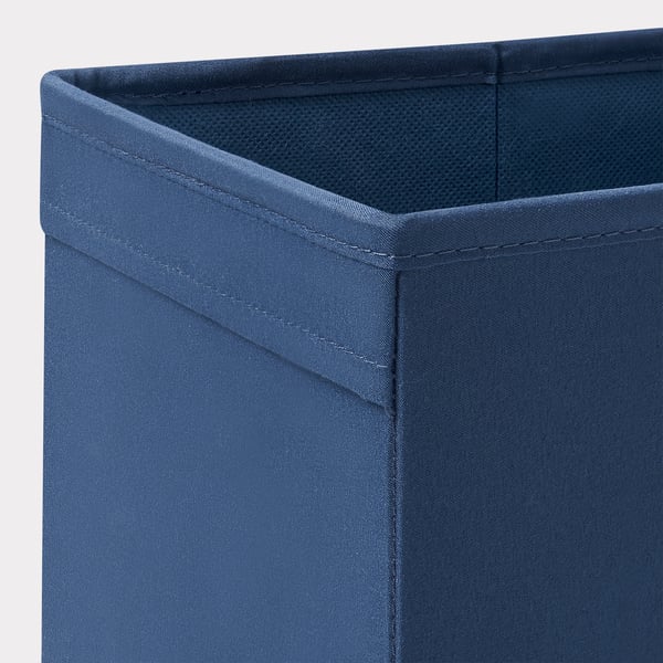 Närbild av en robust förvaringslåda i marinblått tyg, som visar upp hållbara sömmar och kvalitetsmaterial.