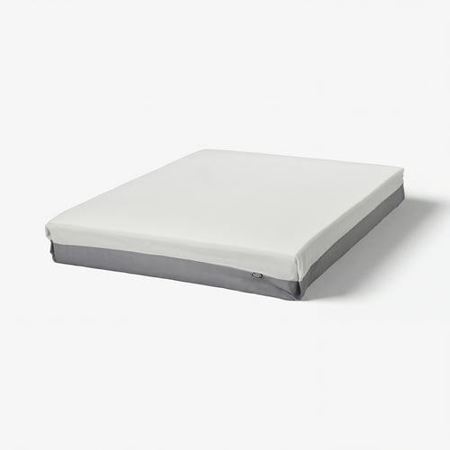 En IKEA FJÄLLÅSEN-madrass i vitt med grå kanter, rektangulär och medelhård.