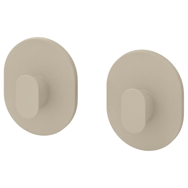 Två beige runda väggkrokar med rektangulära urtag. Enkel och modern design, perfekt för att hänga föremål.