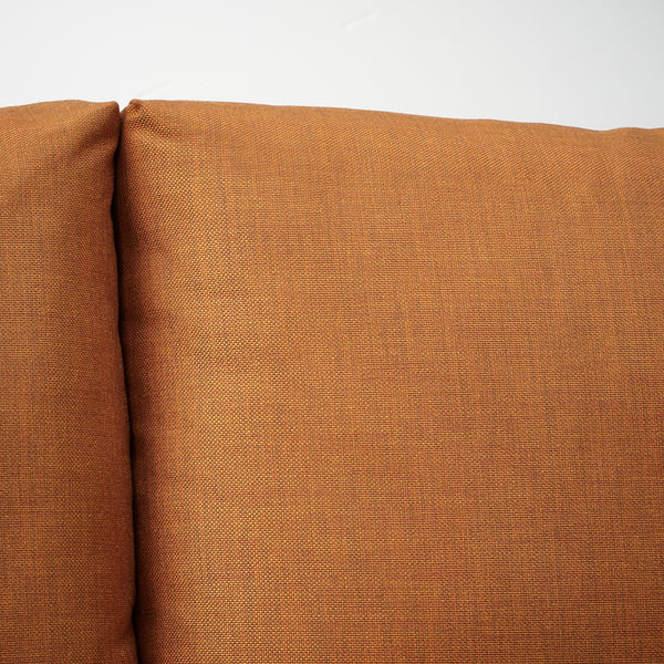 Närbild av en robust, välgjord orange soffa som framhäver kvalitetstyg och robust design.