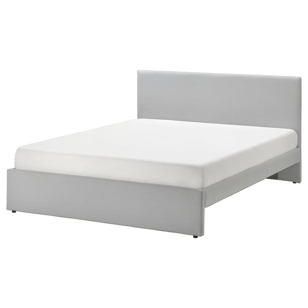 Modern grå stoppad säng med vadderad sänggavel, rena linjer och förvaring under sängen.