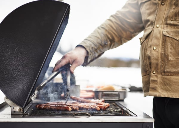 Man grillar korv på GRILLSKÄR med rök.