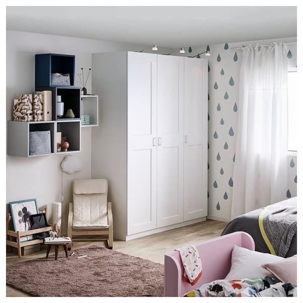 Ett modernt sovrum med en vit GRIMO garderob, med rena, djärva ramar och en fasad kantdesign.