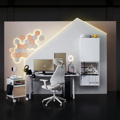 Modern spelutrustning med justerbar spelstol, LED-vägglampor och skrivbord med tillbehör.