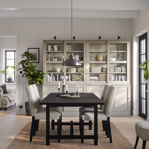 Minimalistisk matplats med HAVSTA sideboard, bord, stolar, lampa, växter och glasmontrar.
