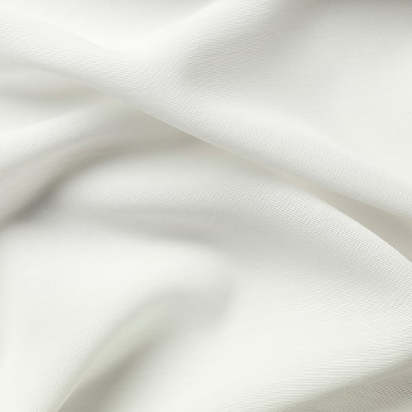 Vita gardiner med fin väv, elegant draperade, erbjuder avskildhet och ljusspridning.