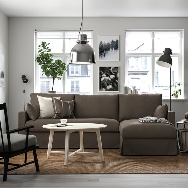 Mysigt vardagsrum med HYLTARP sektion, vitt soffbord, golvlampa och stort fönster.