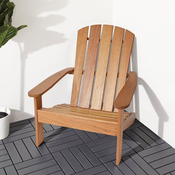 Adirondack-stol i trä på grått däck, perfekt för avkoppling utomhus.