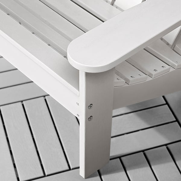 Närbild på en elegant, ljus trästol med böjt armstöd och lamellsits, som visar robust hantverk och slät, jämn finish.