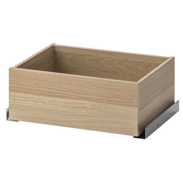 En IKEA KOMPLEMENT låda i ljus ekfärg, gjord av spånskiva och fiberplatta, designad för att organisera kläder och accessoarer.