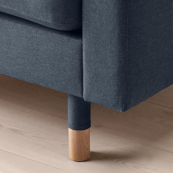 Modern soffa med plyschklädsel och rejäla träben.