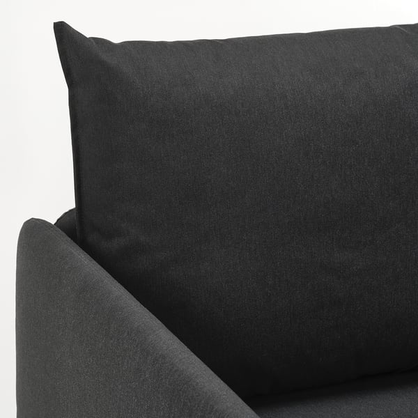 Mörkgrå bäddsoffa, välklädd med plyschkuddar, designad för komfort och lättskött.