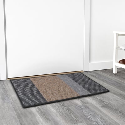Texturerad randig dörrmatta på trägolv, väderbeständig, håller golven rena.