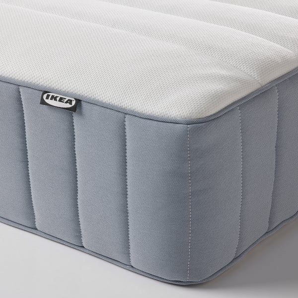 Närbild av IKEA-madrass med dragkedja och tygstruktur i hörnet.