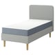 IKEA LYNGÖR säng: grå, modern, stoppad ram med ljusa träben, mjuk vit madrass, minimalistisk design.