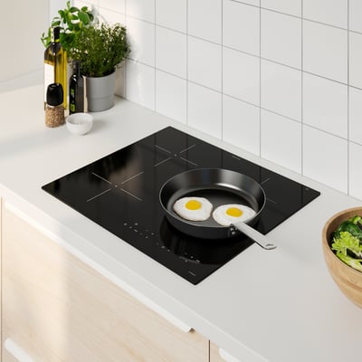 Modernt kök med induktionshäll MATMÄSSA, stekpanna, sallad och tillbehör.