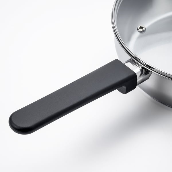 Traktörpanna i rostfritt stål med svart handtag, robust och elegant design, perfekt för olika hällar inklusive induktion.
