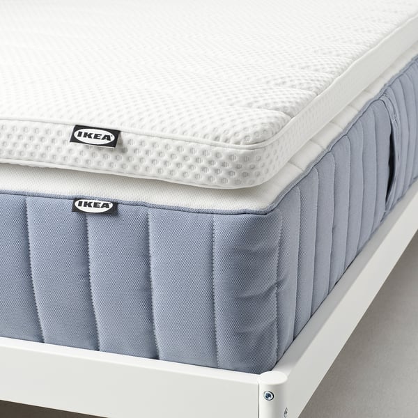 En 1 cm IKEA bäddmadrass i skum, mjuk och tryckavlastande, med ett tvättbart, stretchigt överdrag.