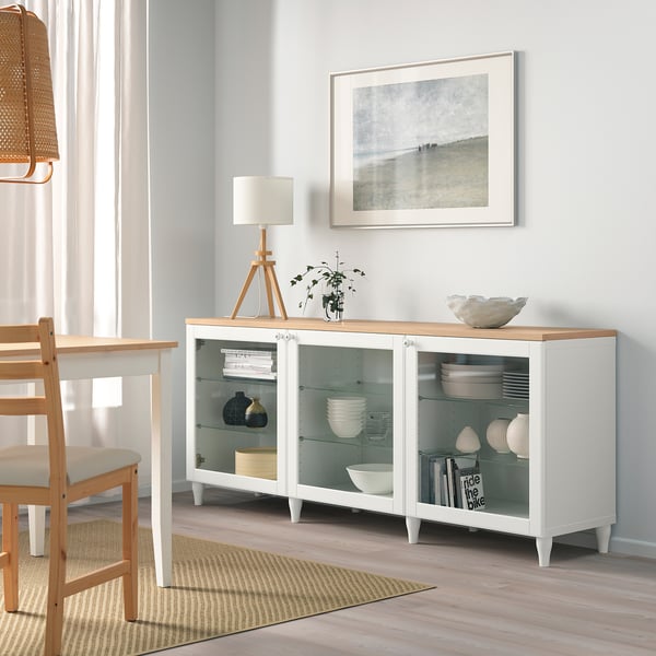 Vitt OSTVIK sideboard med glasdörrar, förvaring av fat och vaser, i minimalistisk matmiljö.