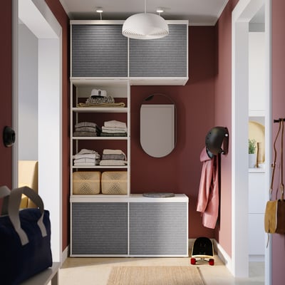 Organiserad garderob med grå PLATSA-hyllor, hängande jacka, skateboard och hjälm. Modern design med skjutdörrar.