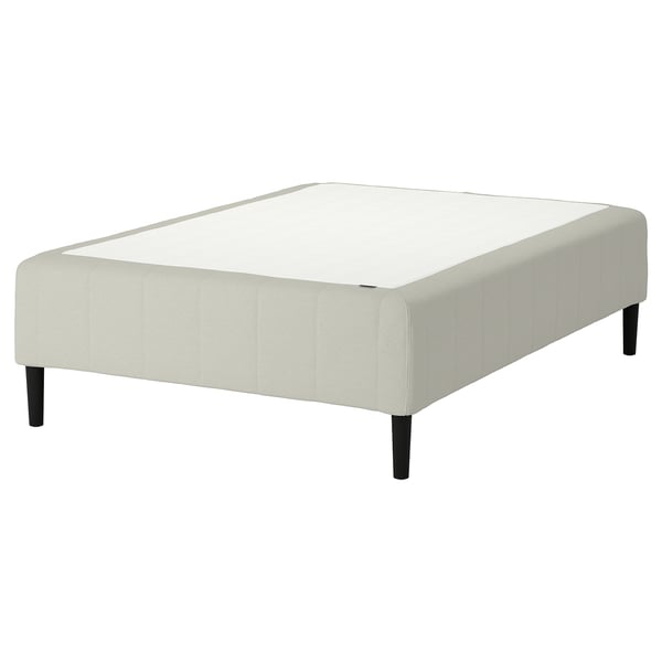 En IKEA RÅHOLMAR sängbotten i beige med rejäla svarta ben, designad för komfort och enkel montering.