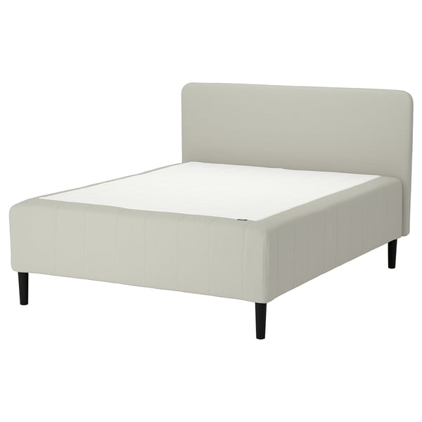 En vit säng RISHÖJDEN med vadderad sänggavel och svarta ben. Det är en modern, minimalistisk design.