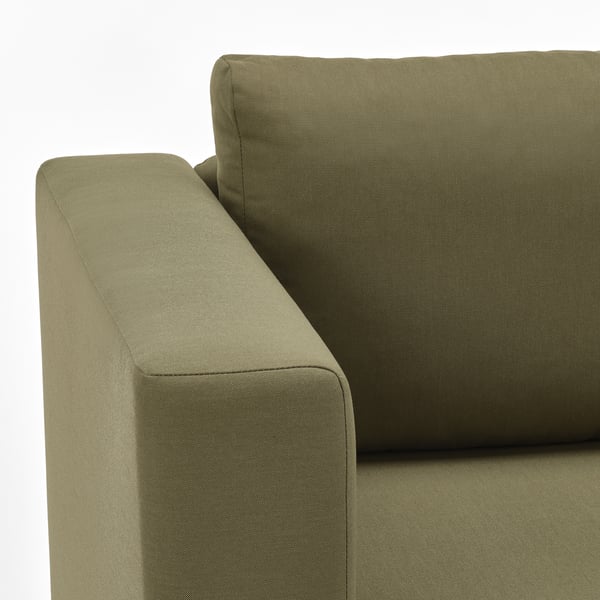 Olivgrön soffa i närbild, som visar upp kvalitetstyg och designdetaljer.