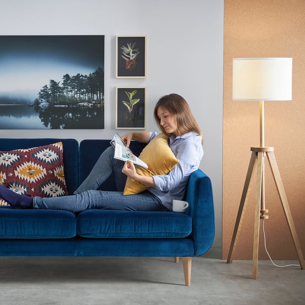 Kvinna som läser på den blå SMEDSTORP soffan i mysigt vardagsrum.