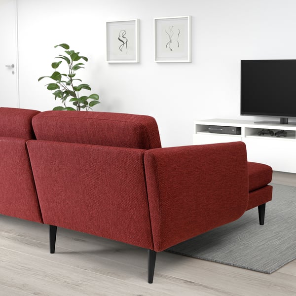 Modernt vardagsrum med röd SMEDSTORP soffa, plattskärms-tv, abstrakt konst, växt.
