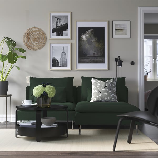Modernt vardagsrum med grön sektionssoffa SÖDERHAMN, konst, växter och naturligt ljus.